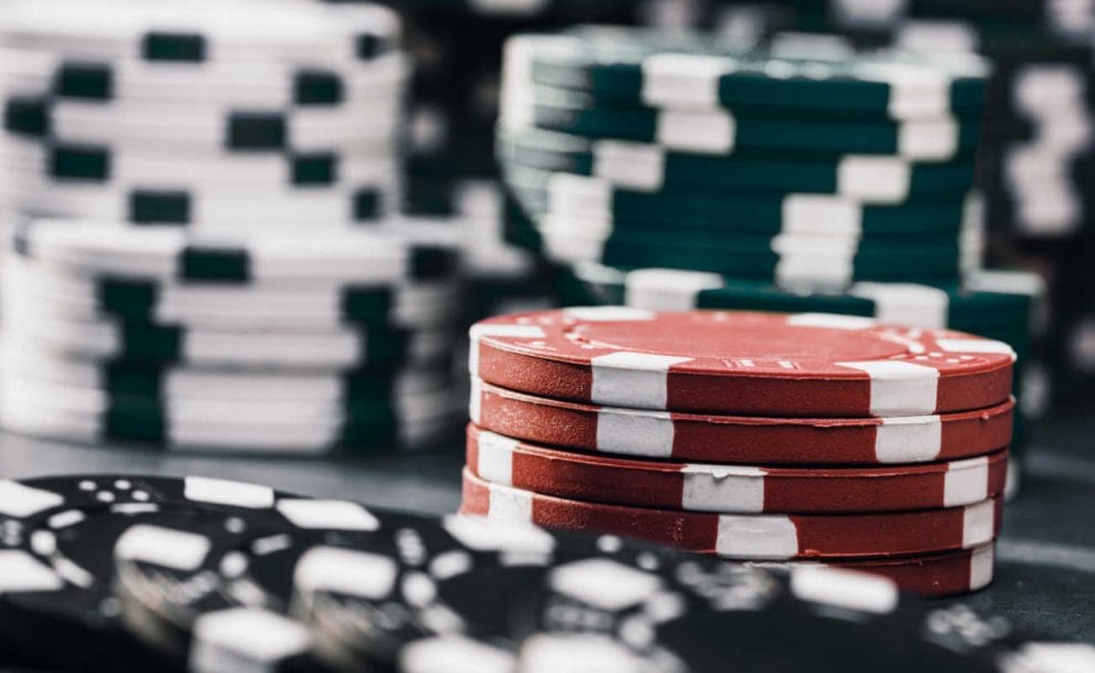 A red stack of chips stands out among black poker chips.