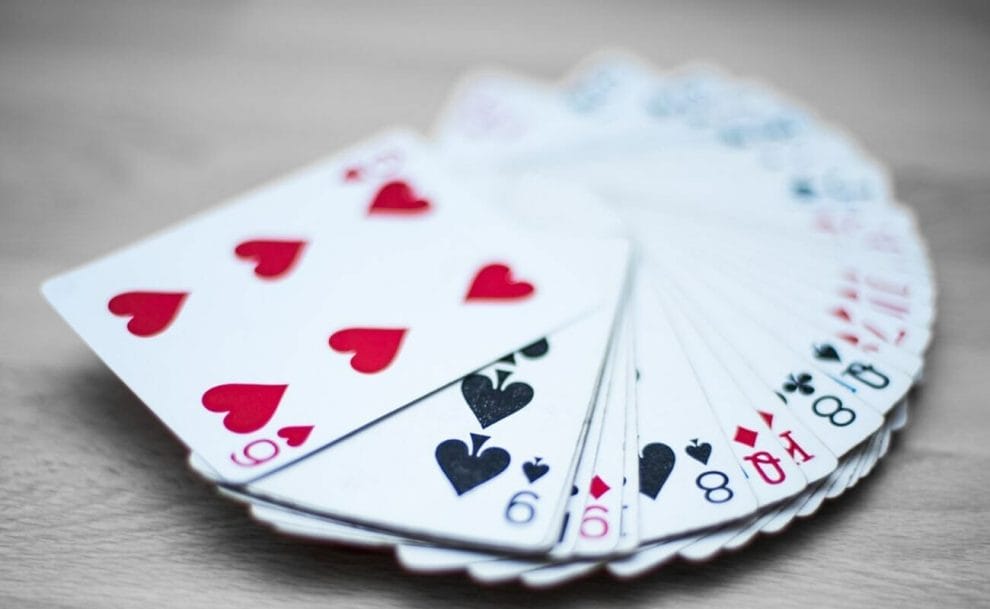 A fanned-out deck of cards on a gray table.
