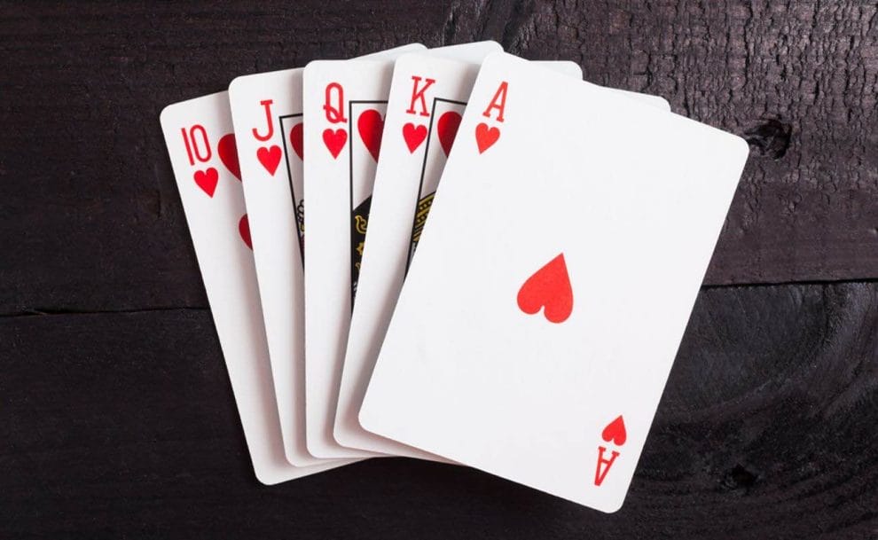 A hand of playing cards that comprise a royal flush of hearts.