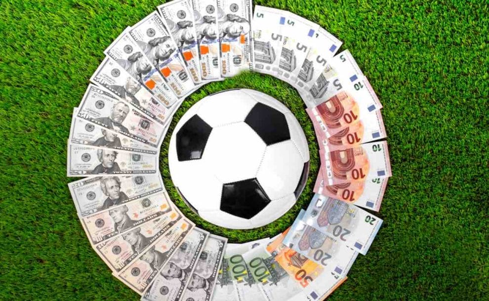 A soccer ball surrounded by paper currency of varying denominations.