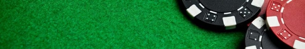 red and black poker chips on a green felt poker table