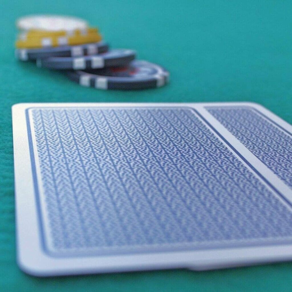 Header image - two blue playing cards face down on a blue surface with a stack of chips behind them