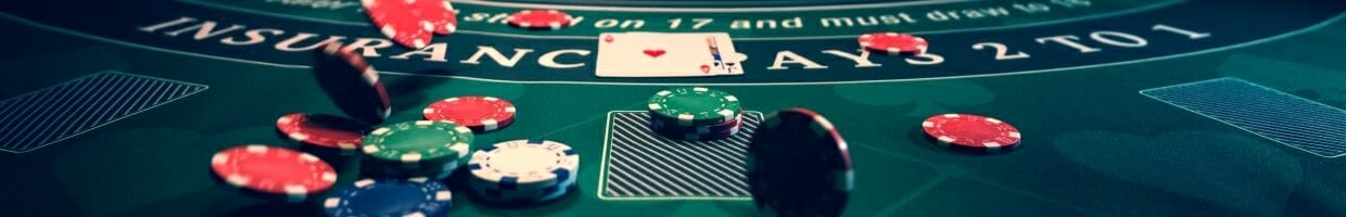 Hero image, poker chips scattering on a poker table with two cards face up in the background