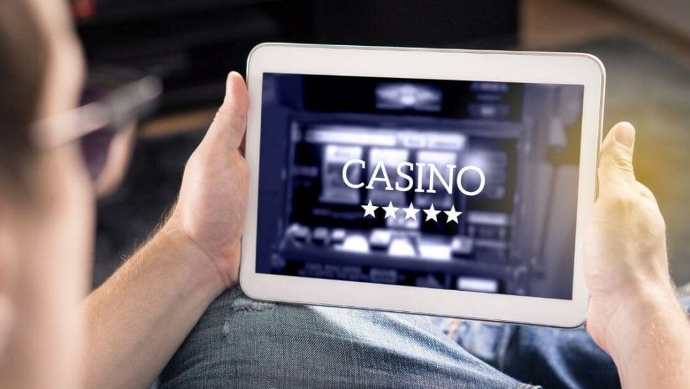 Body image, man holding a digital tablet displaying an online casino 