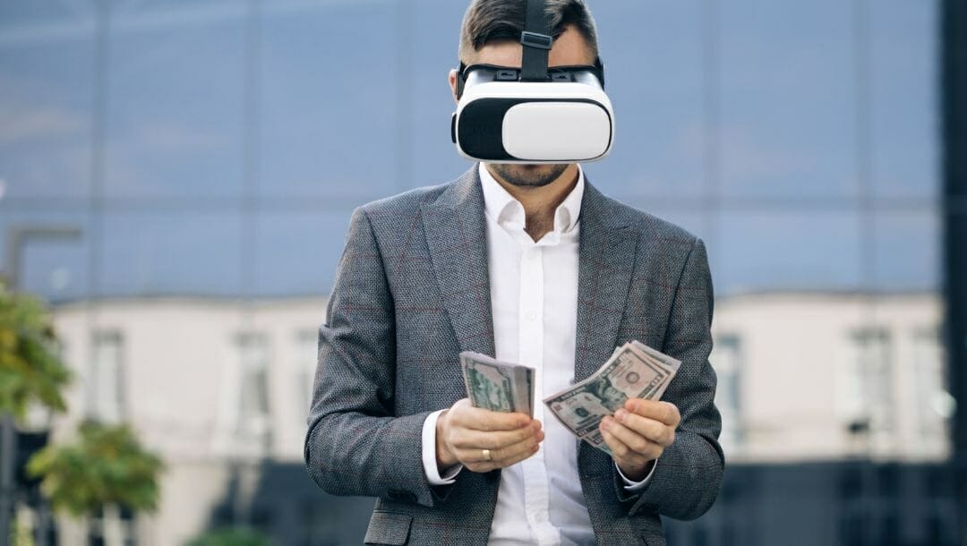 A person in a suit wears a VR headset while counting money.