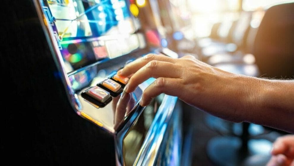 Body image, close up of a hand playing a slot machine in a casino 