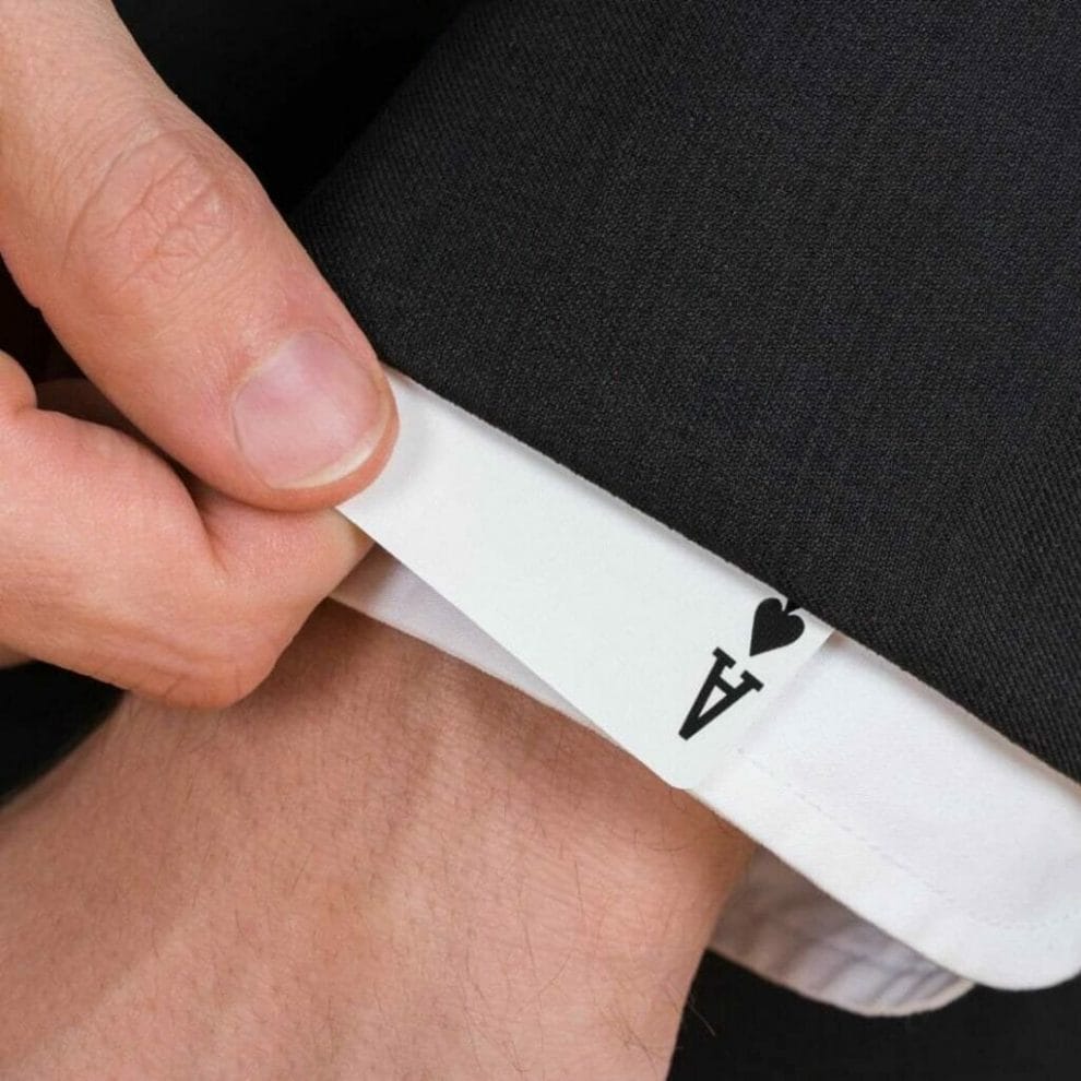 close up of man pulling an ace of spades playing card out of his suit sleeve