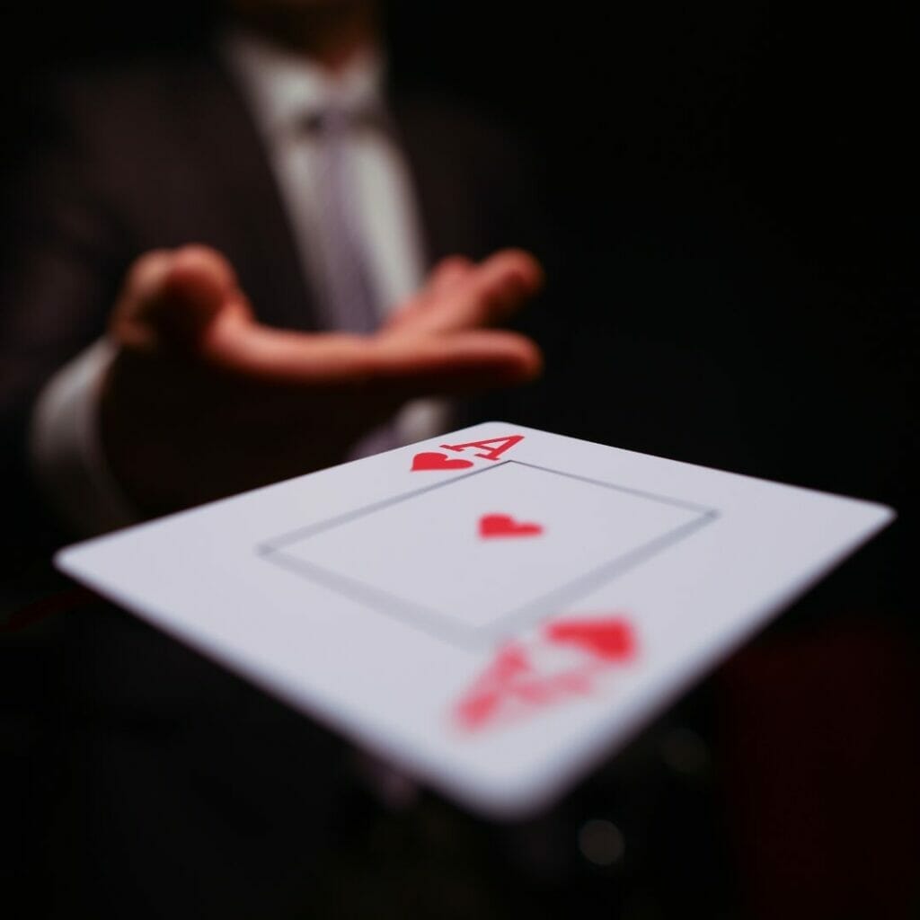 Header image, a man throwing an ace of hearts playing card towards the screen