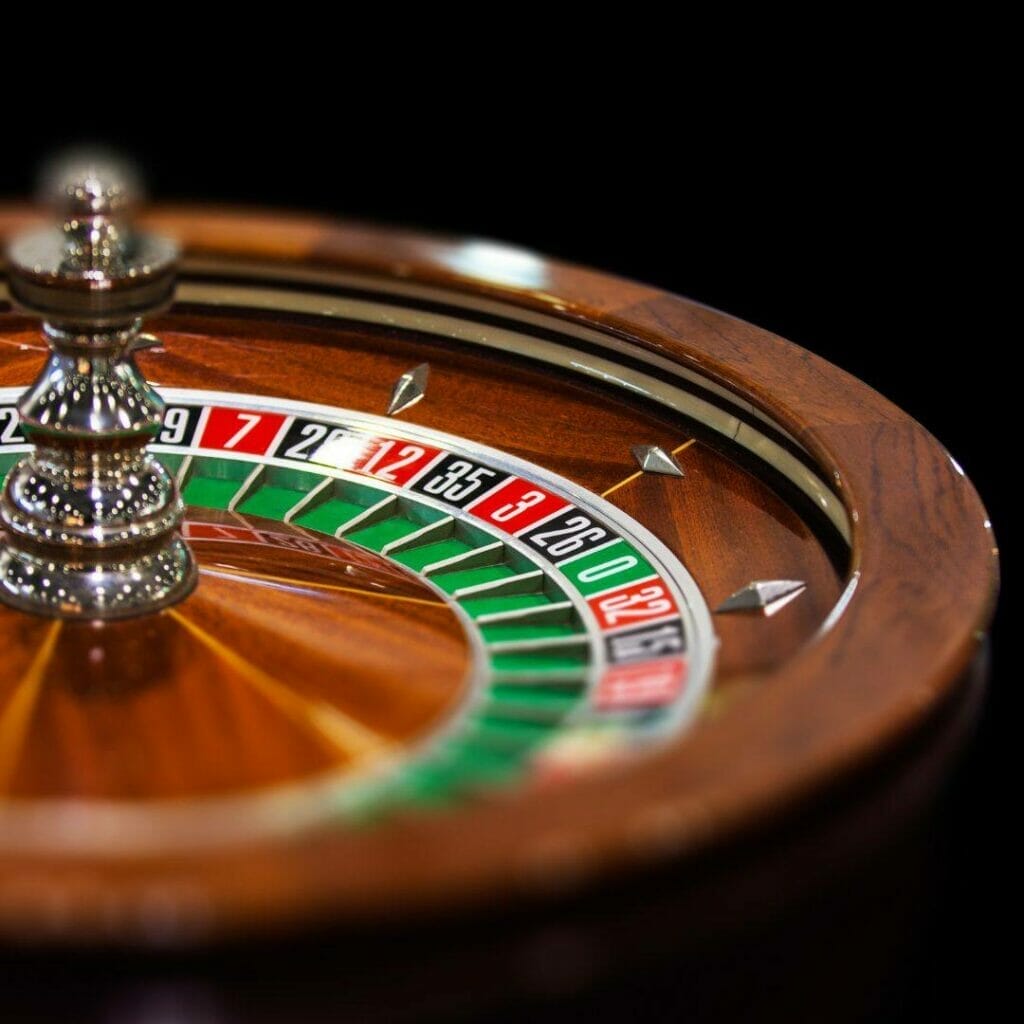 Header image, close up of a wooden roulette wheel with a dark black background
