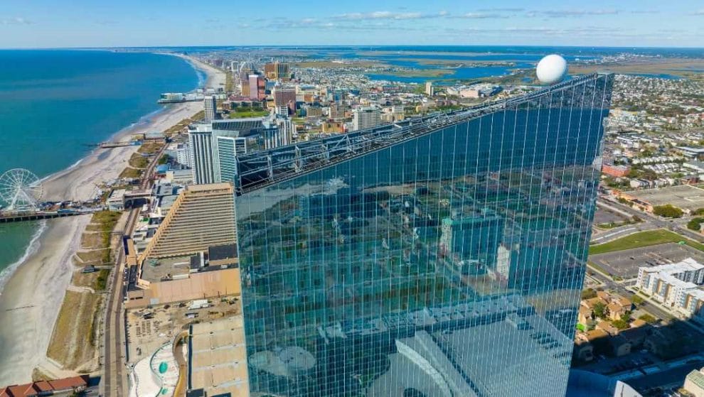Body - Aerial shot of Ocean Casino Resort building with views of the Atlantic City boardwalk and beachfront during daytime 