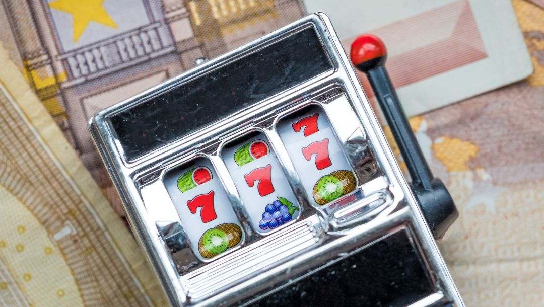 body image, mini toy slot machine with money underneath it