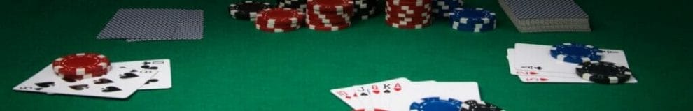 Poker table with chips and cards on it during a game.
