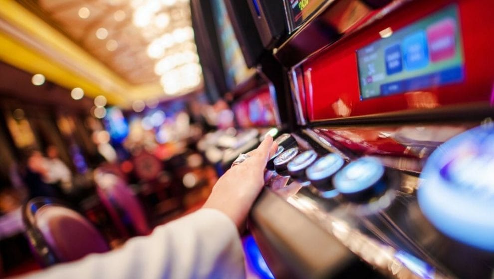 close up of a person pressing a button on a casino game machine in a casino 