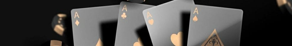 Four black and gold Ace playing cards surrounded by casino chips.