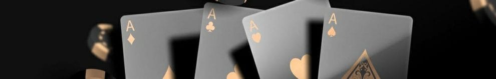 Four black and gold Ace playing cards surrounded by casino chips.