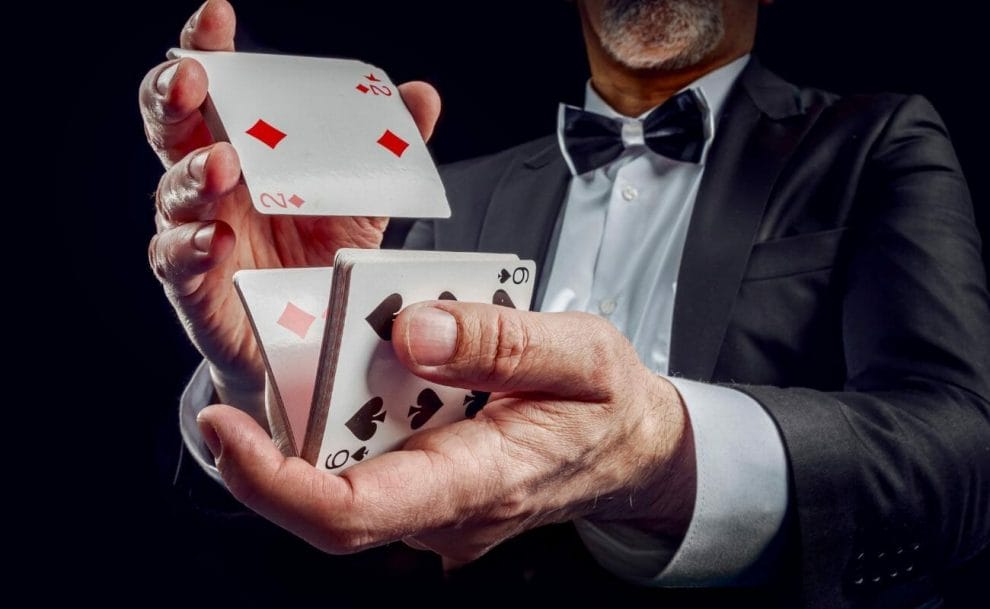 a man in a suit and bowtie is shuffling playing cards