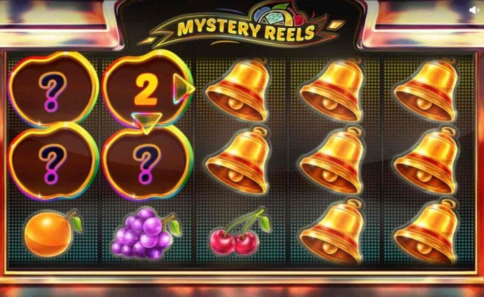 A screenshot of the Wild symbol on the Mystery Reels slot game with two more spaces to expand onto (replacing the symbols); the rest of the reel is filled with Gold Bells, an orange, grapes, and a cherry symbol.
