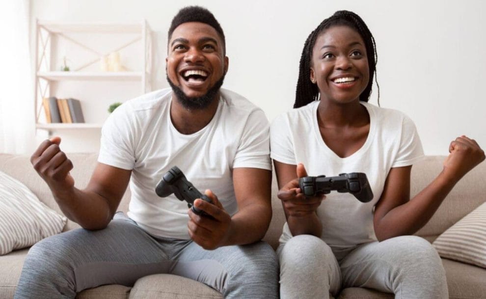 A couple playing video games celebrating a win.