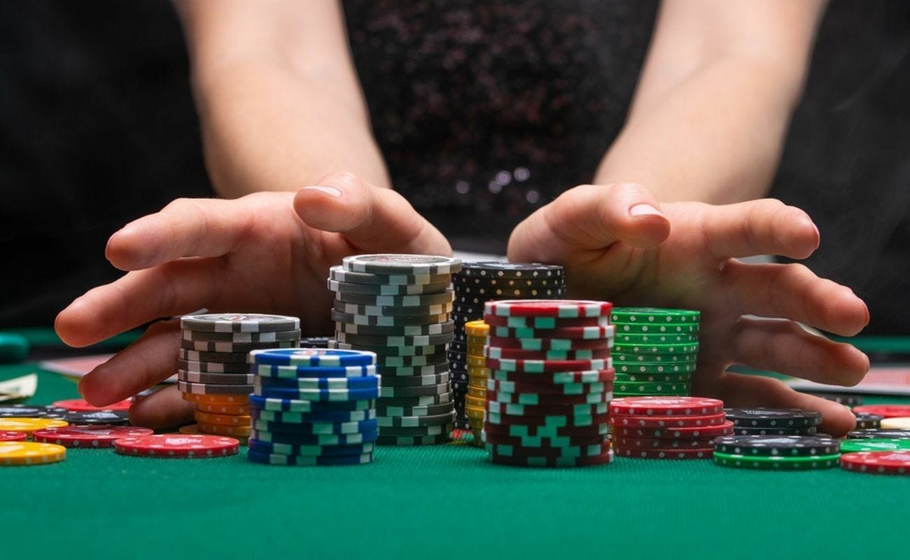 Hands surrounding stacks of poker chips.