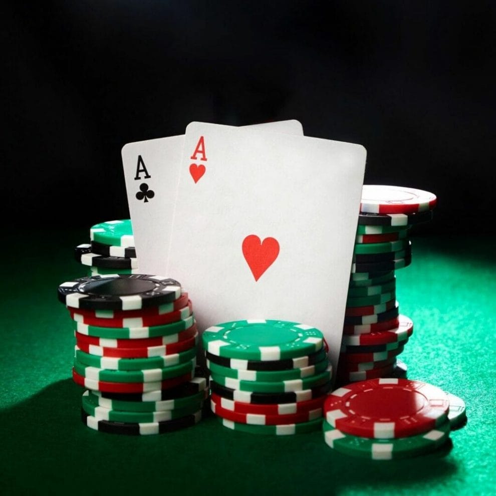 A pair of aces leaning against stacks of poker chips.