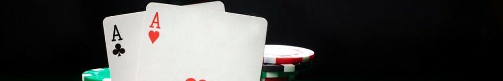 A pair of aces leaning against stacks of poker chips.