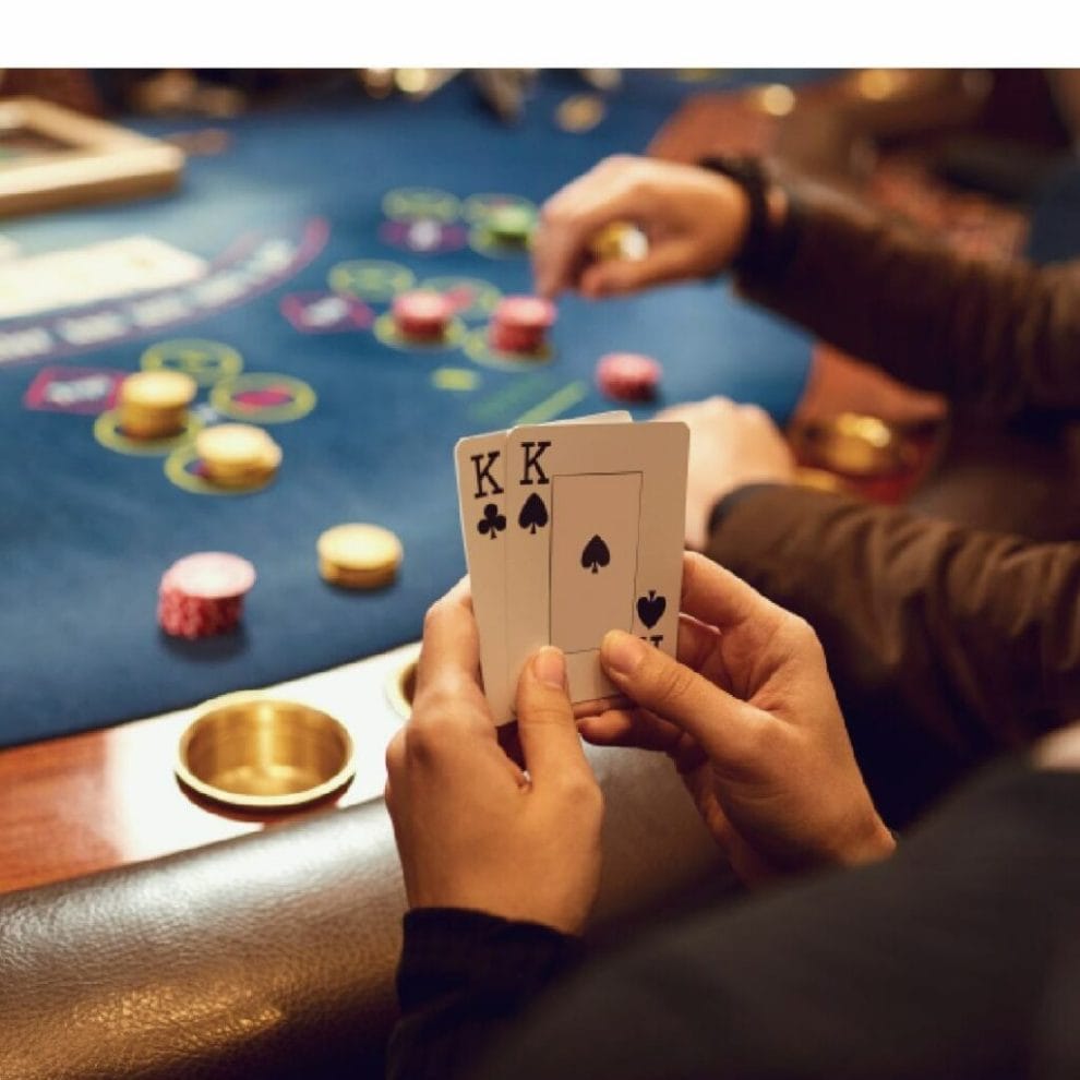 A player holds two kings in their hand at the poker table