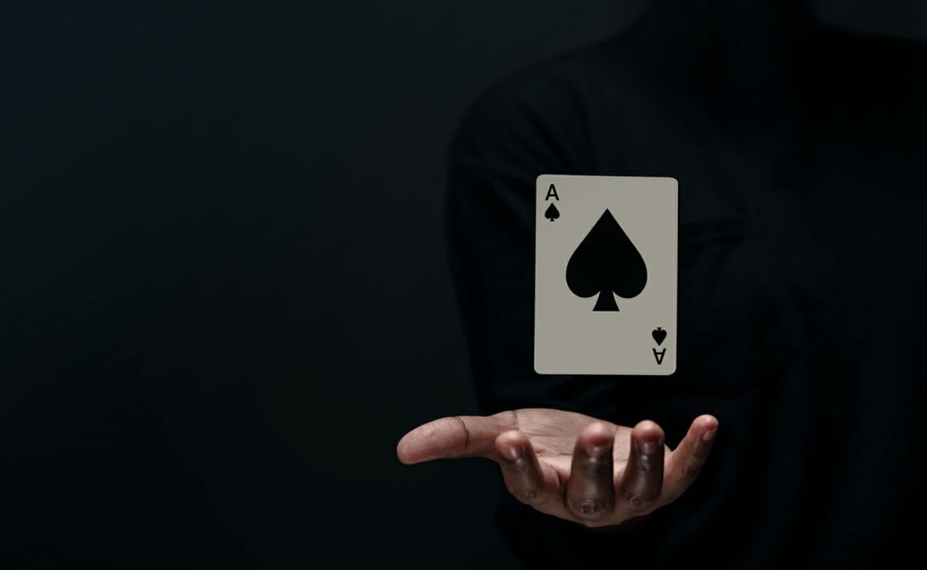 A magician levitating an Ace of Spades playing card