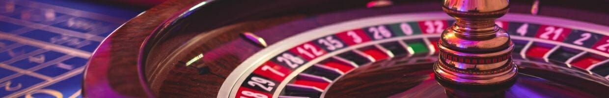 close up of a wooden roulette wheel at a roulette table in a casino 