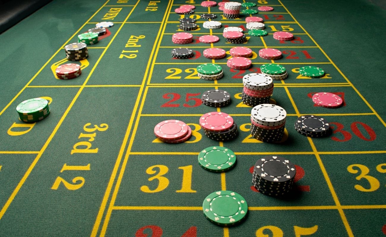 Stacks of casino chips placed on various betting options on a roulette table.