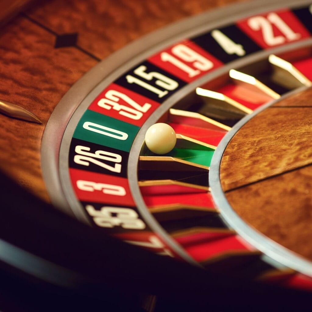 A close-up of the roulette ball in the green zero pocket on a roulette wheel.