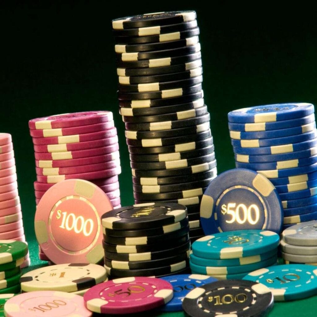 multi-colored poker chips stacked on a poker table in a casino