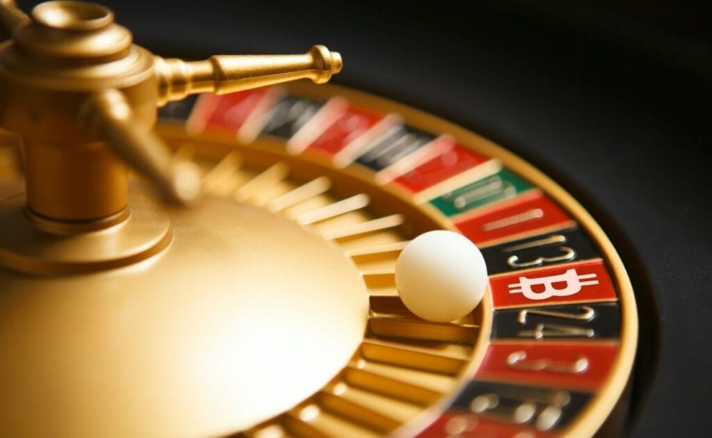 a little white roulette ball in a roulette wheel has landed on a Bitcoin icon 