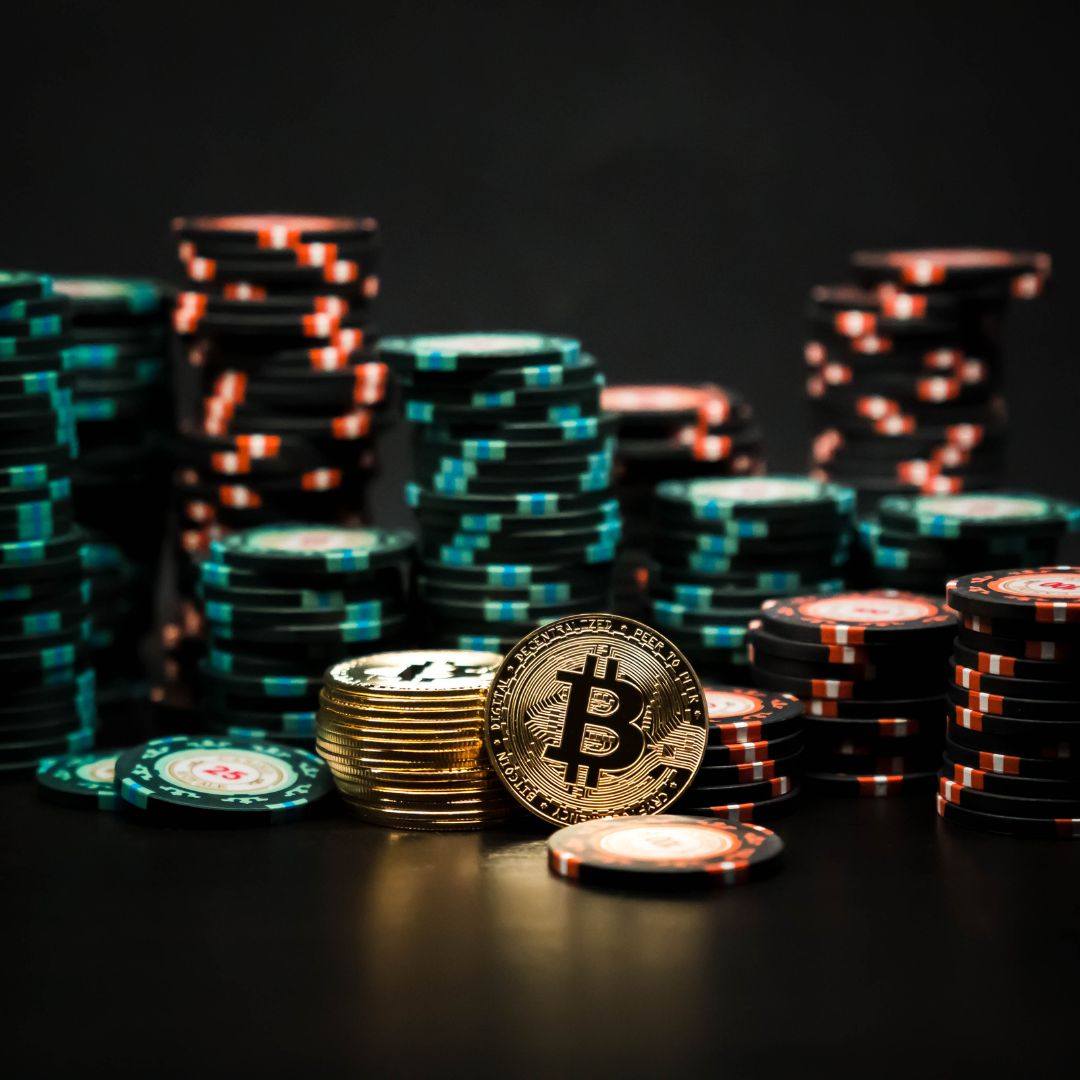 a stack of Bitcoins among stacks of poker chips on a dark surface