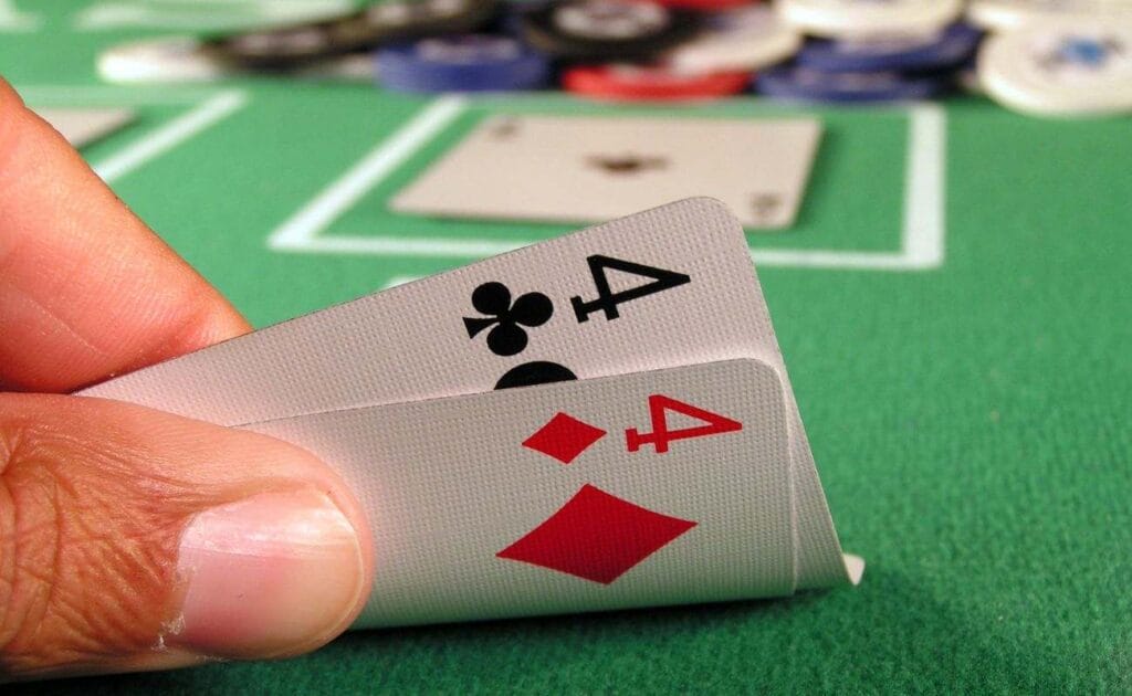 close up of a pocket pair of fours on a green felt poker table during a poker game  