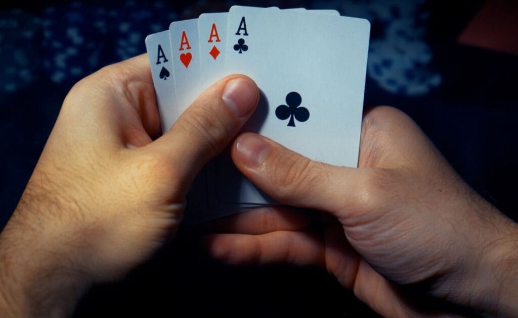 a person holding four of a kind aces