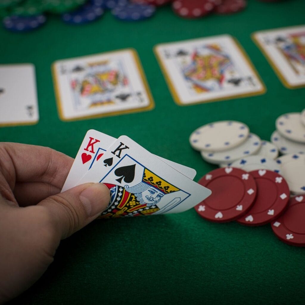 a player checking their pocket pair of kings on a green felt poker table
