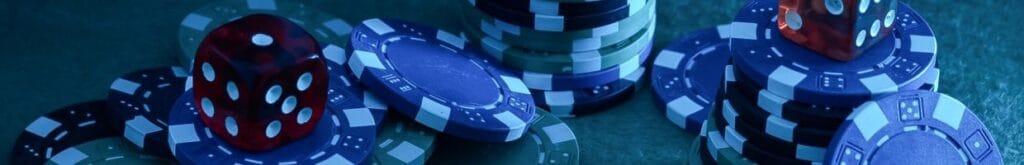 poker chips and red dice in blue light on a poker table