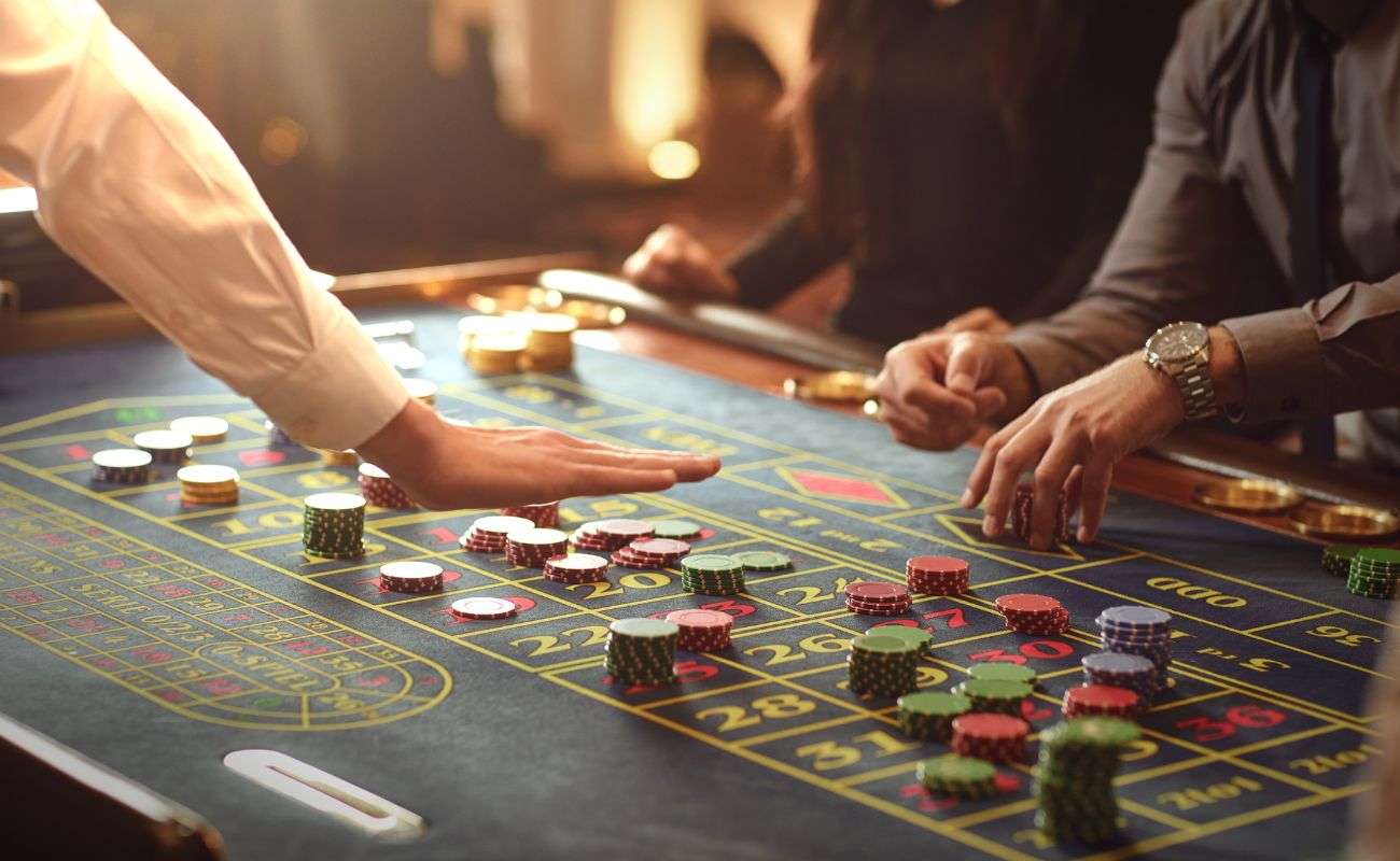 people placing bets on a roulette table in a casino