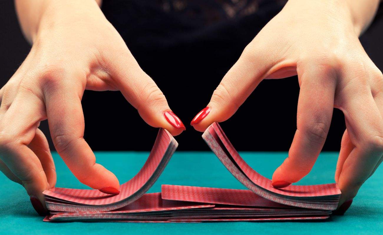 a close up of a person shuffling a deck of playing cards