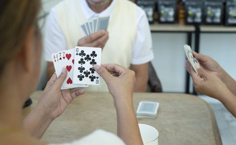an over-the-shoulder view of three people playing poker together