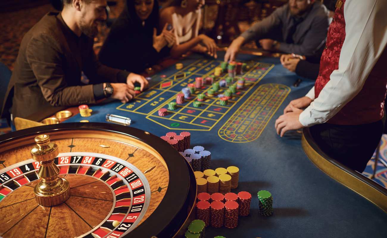 Roulette table with players and a roulette dealer.