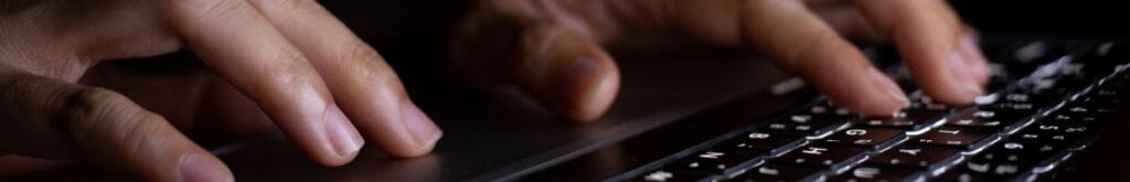 close up of a person typing on a laptop keyboard
