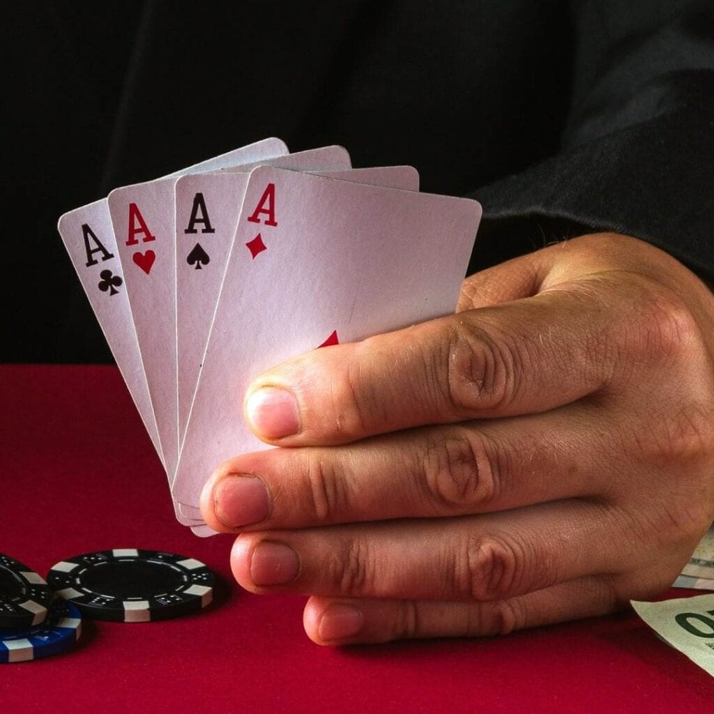 A man holding four aces in his hand.