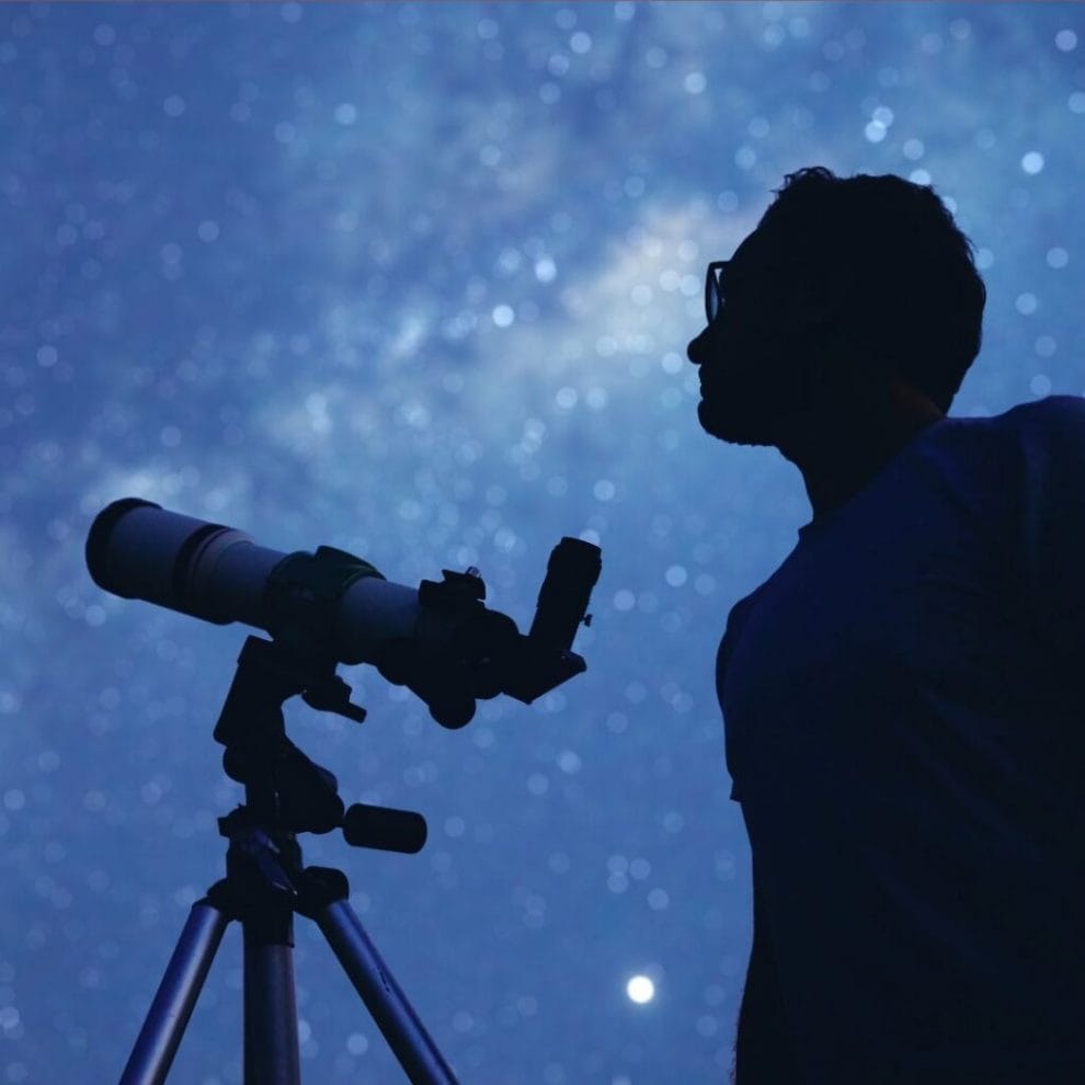 astronomer with a telescope watching the stars and moon