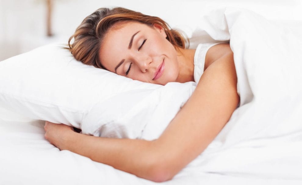 A woman sleeping peacefully in white linen