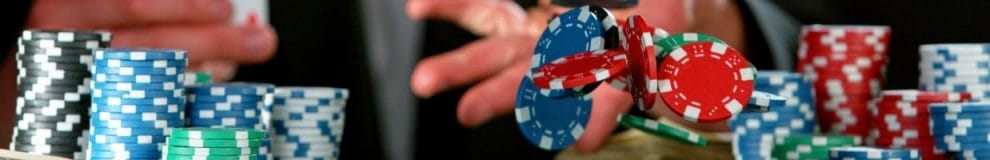  a man throwing poker chips forward between stacks of poker chips