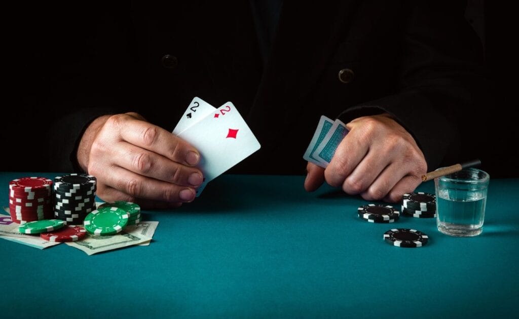 A person holding a pair of twos at the poker table