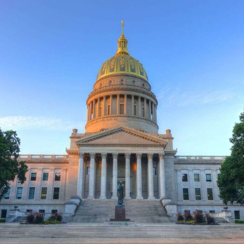 front view of the golden-domed State Capitol building in Charleston, West Virginia at sunrise