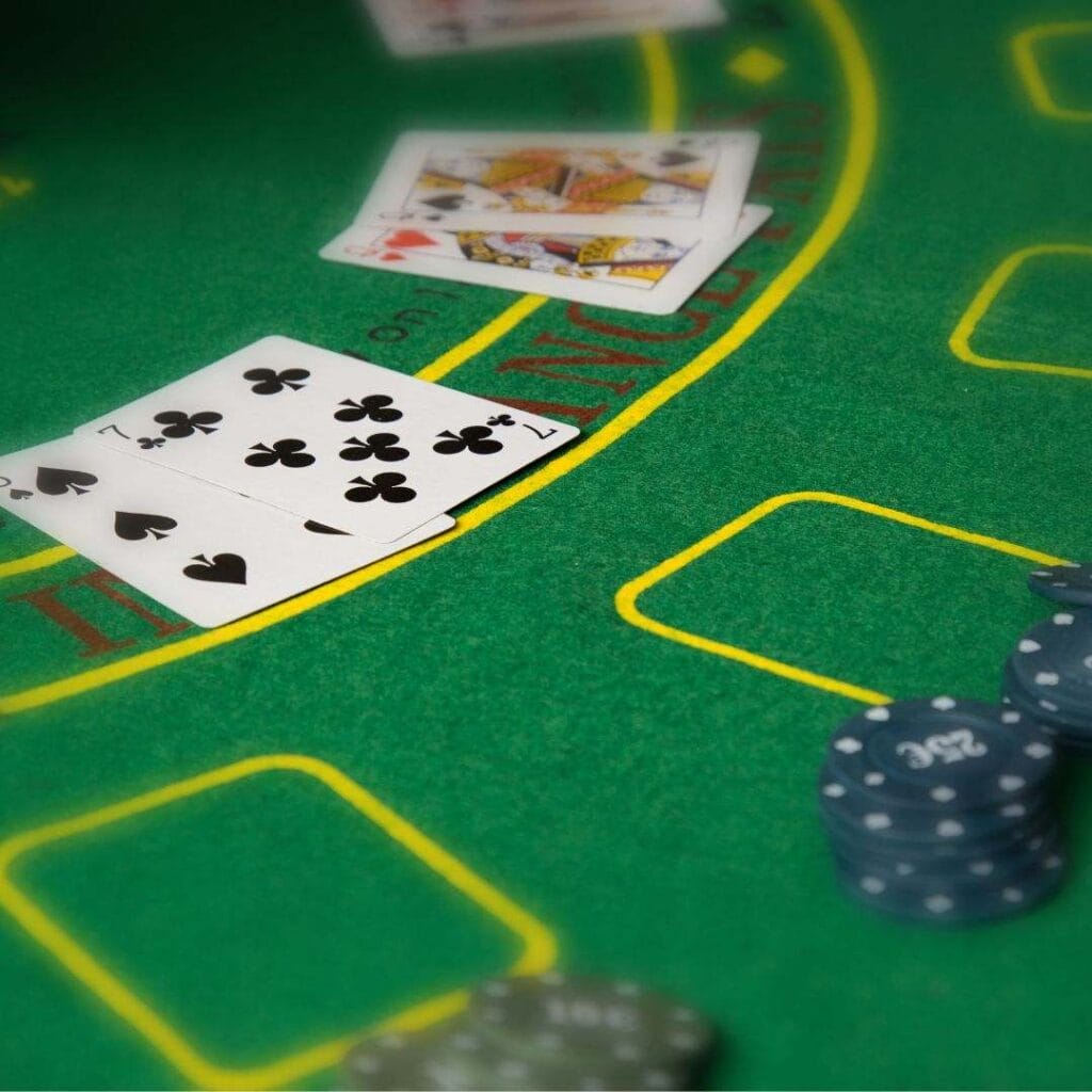 Playing cards and casino chips arranged on a blackjack table.