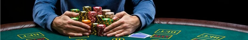 A person sitting at a poker table, collecting chips.